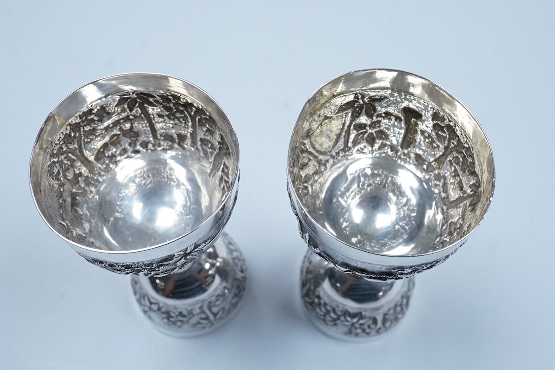 A pair of Indian embossed white metal single and double ended measures, 11.9cm, 5.2oz.